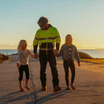 在夕阳的背景下，Hydro员工穿着引人注目的衣服和他的两个孩子散步